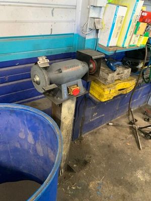 un seau bleu posé à côté d'un tonneau bleu dans un garage