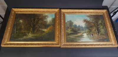 two framed paintings of a river and trees on a table