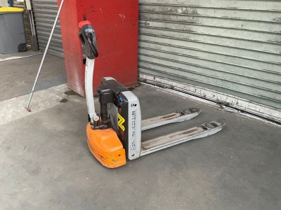 a forklift that is sitting in front of a garage door