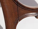 a close up view of a wooden chair with a curved back