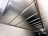a metal ceiling in a room with a white wall