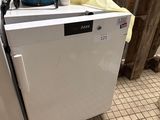 une machine à laver et un sèche-linge blancs posés sur un sol carrelé