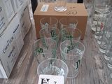 bottles and glasses on a table with boxes of beer