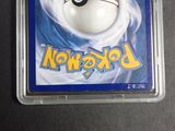 a pokemon card in a plastic container on a table