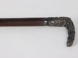 an old cane with a wooden handle on a white surface