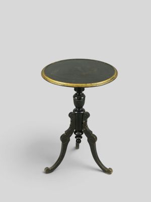 une table d'appoint noire et dorée avec un plateau noir