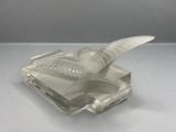 a glass bird that is sitting on top of a book