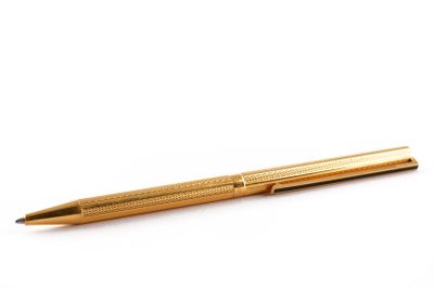 un stylo doré sur fond blanc, avec un espace réservé au texte