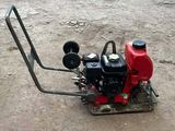 a small red machine that is sitting on the ground