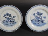 deux assiettes bleues et blanches ornées de fleurs et d'arbres