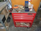 une armoire à outils rouge, sur laquelle sont posés des outils, dans un garage