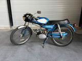 a blue motorcycle parked in a garage next to a garage door