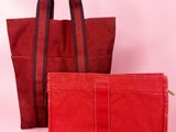 a pair of red bags sitting next to each other on a pink background