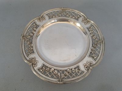 an antique silver plate with a floral design on the rim