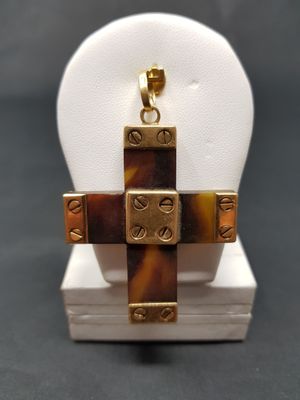 a close up of a cross pendant on a display stand