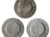 trois assiettes ornées de motifs, posées sur une surface blanche