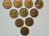 a bunch of gold coins sitting on top of a white surface