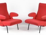 pair of red lounge chairs with black legs on a white background