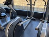 two stationary exercise bikes in a gym with a view of a field