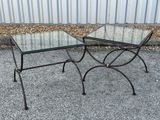 pair of glass and iron side tables on a gravel ground