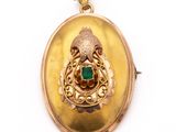 an image of a gold locke with a green stone in the center