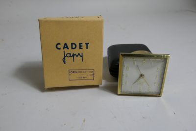 a small clock that is sitting in front of a box