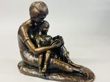 statue en bronze représentant une femme et un enfant assis sur un rocher