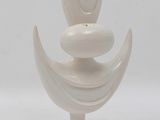 a white vase with a face on it on a stand