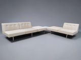 two white couches sitting next to each other on a gray surface