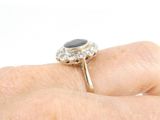 an image of a person ' s hand holding a ring with a black stone