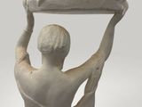 statue of a woman holding a tray over her head