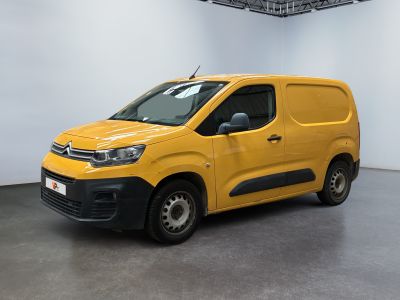 Une camionnette jaune est garée dans une pièce blanche