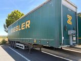 un gros camion vert garé sur le bord de la route