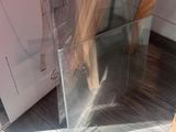 a clear glass container with a wooden handle on the floor