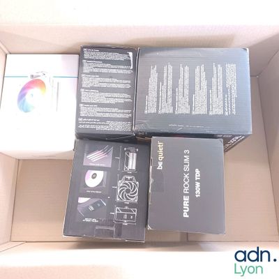 quatre boîtes contenant du matériel électronique, rangées dans un carton