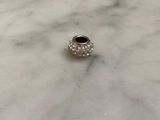 a close up of a silver bead on a marble surface