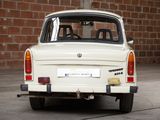 a small white car parked in front of a brick wall