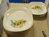 two plates with flowers on them sitting on a table