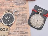 a pocket watch and a pocket watch sitting on a piece of paper