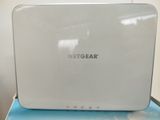 a white netgear router sitting on top of a blue box