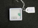 a small white box with a green bead on it