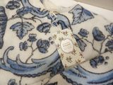 a tag on a blue and white floral print sweater