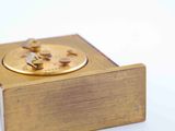 a gold clock sitting on top of a wooden box