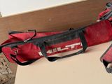 a red duffel bag sitting on a table next to a pair of shoes