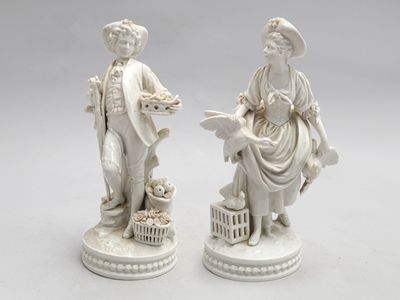paire de figurines en porcelaine blanche représentant un homme et une femme accompagnés d'un chien