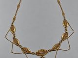a gold necklace with a bird on it