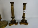 three brass candlesticks on stands with a price tag on them