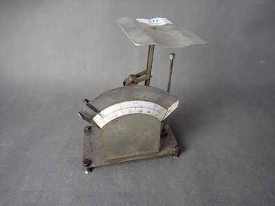 une vieille balance surmontée d'une plaque métallique