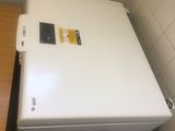 un réfrigérateur blanc dans un coin d'une petite pièce
