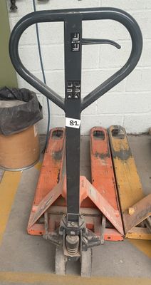 une photo d'un chariot élévateur posé sur des palettes dans un garage